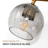 Close-up of a gold bathroom vanity light with gray crackle glass shade, angled view