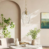 Gold chain suspends hammered glass pendant light over a round table in a softly lit room