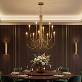 Ten-light brushed brass chandelier with curved arms, hanging over a dining table in a wood-paneled room