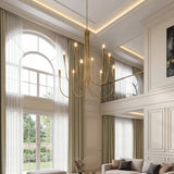 Ten-light brushed brass chandelier with U-shaped arms, adjustable, hanging in a high-ceilinged living room