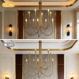Ten-light brushed brass chandelier with curved arms, lit, in a room with wall sconces