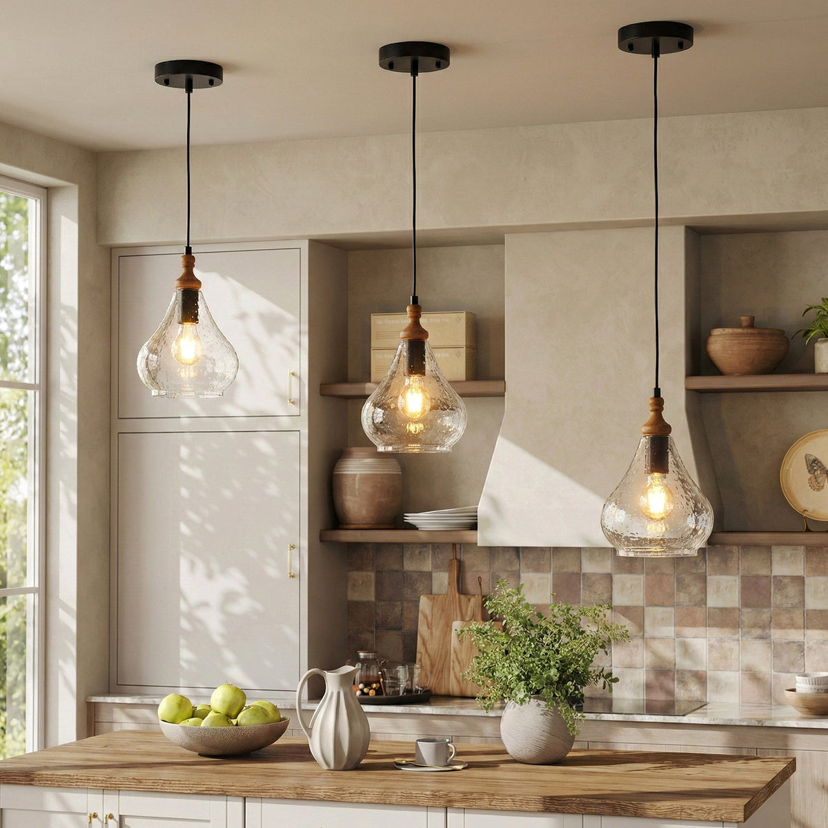 Three black-finished farmhouse seeded glass teardrop pendant lights with wood accents hanging over a kitchen island
