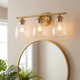 Gold bathroom vanity light with three bubble glass shades mounted above a round mirror
