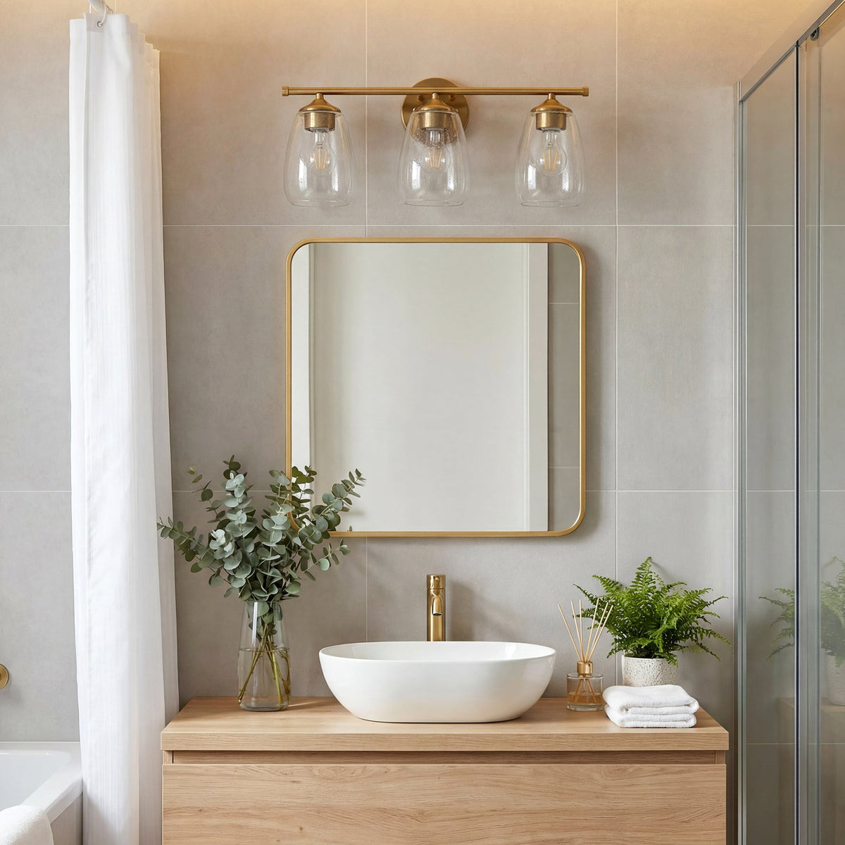 Gold bathroom vanity light with three bubble glass shades mounted above a mirror