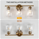 Gold bathroom vanity light with three bubble glass shades, shown installed facing down