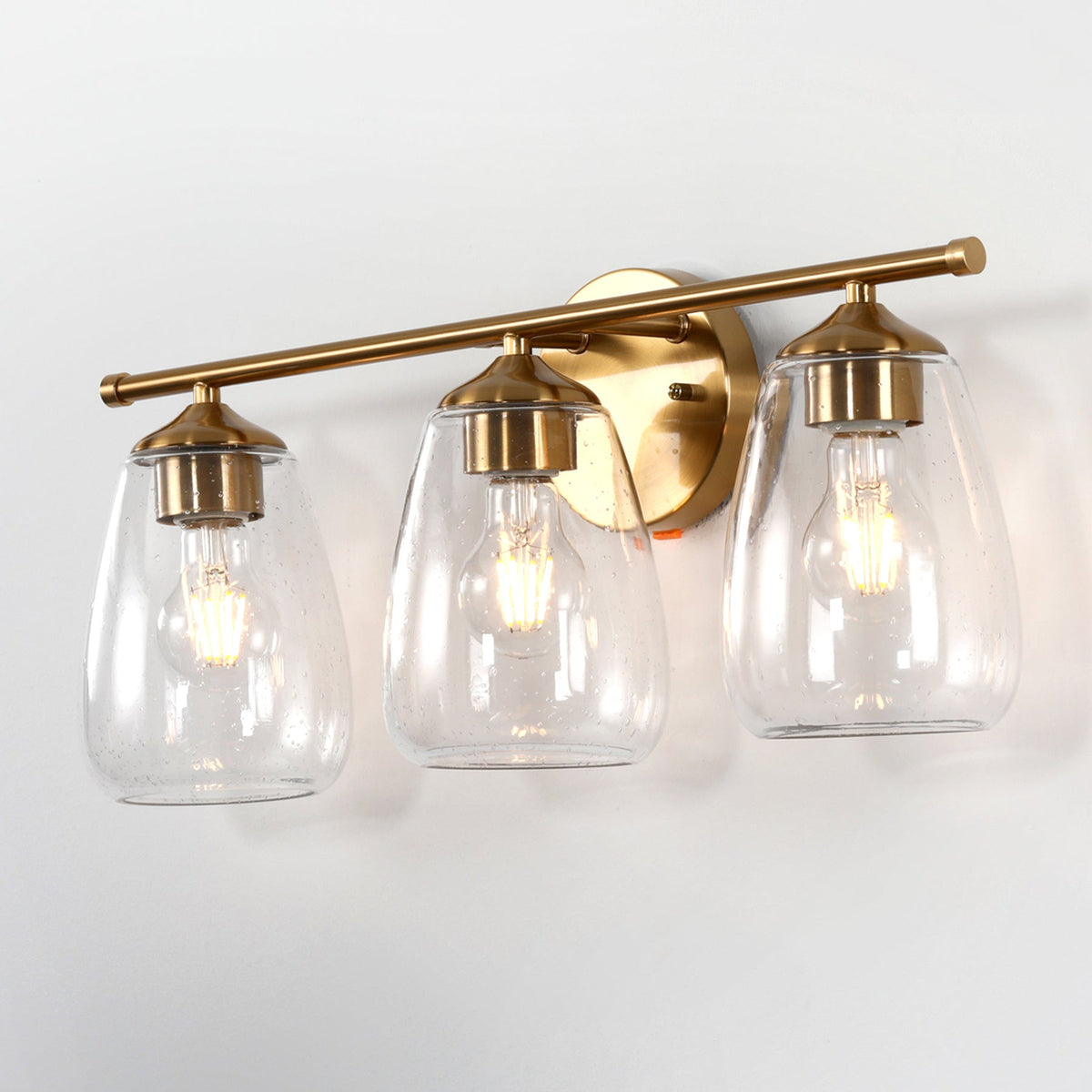 Three-light gold bathroom vanity light with bubble glass shades, shown from front angle