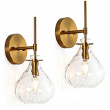 Two gold wall sconces with hammered glass shades, shown lit from within