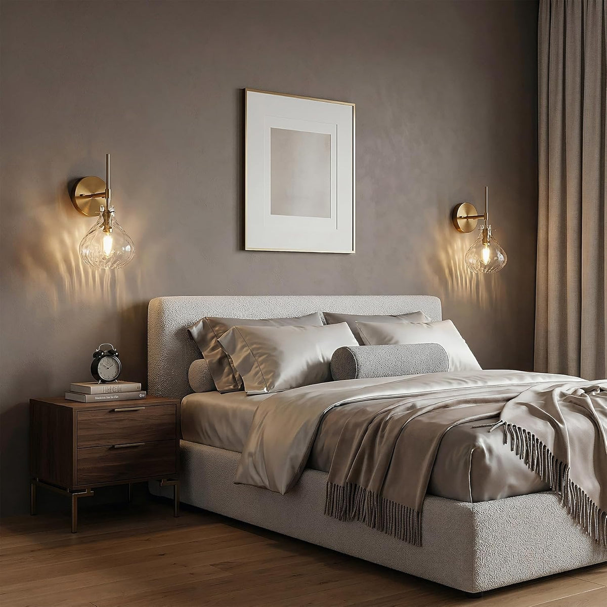 Two gold wall sconces with hammered glass shades mounted on a gray wall above a bed
