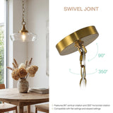 Gold pendant light with clear glass shade, shown hanging over wooden table in dining room