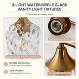 Close-up of brushed brass base of three-light vanity light with water ripple glass shade