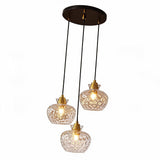 Black and gold three-light pendant with textured glass shades, shown from above
