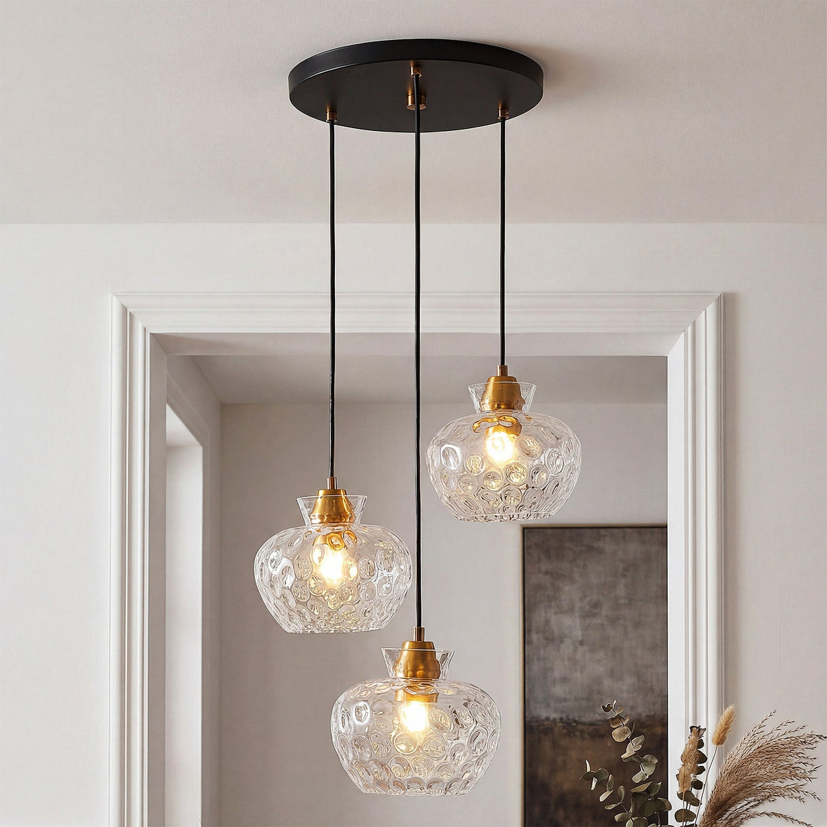 Black ceiling-mounted pendant with three gold-finished glass shades featuring water ripple texture