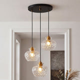 Black ceiling-mounted pendant with three gold-finished glass shades featuring water ripple texture