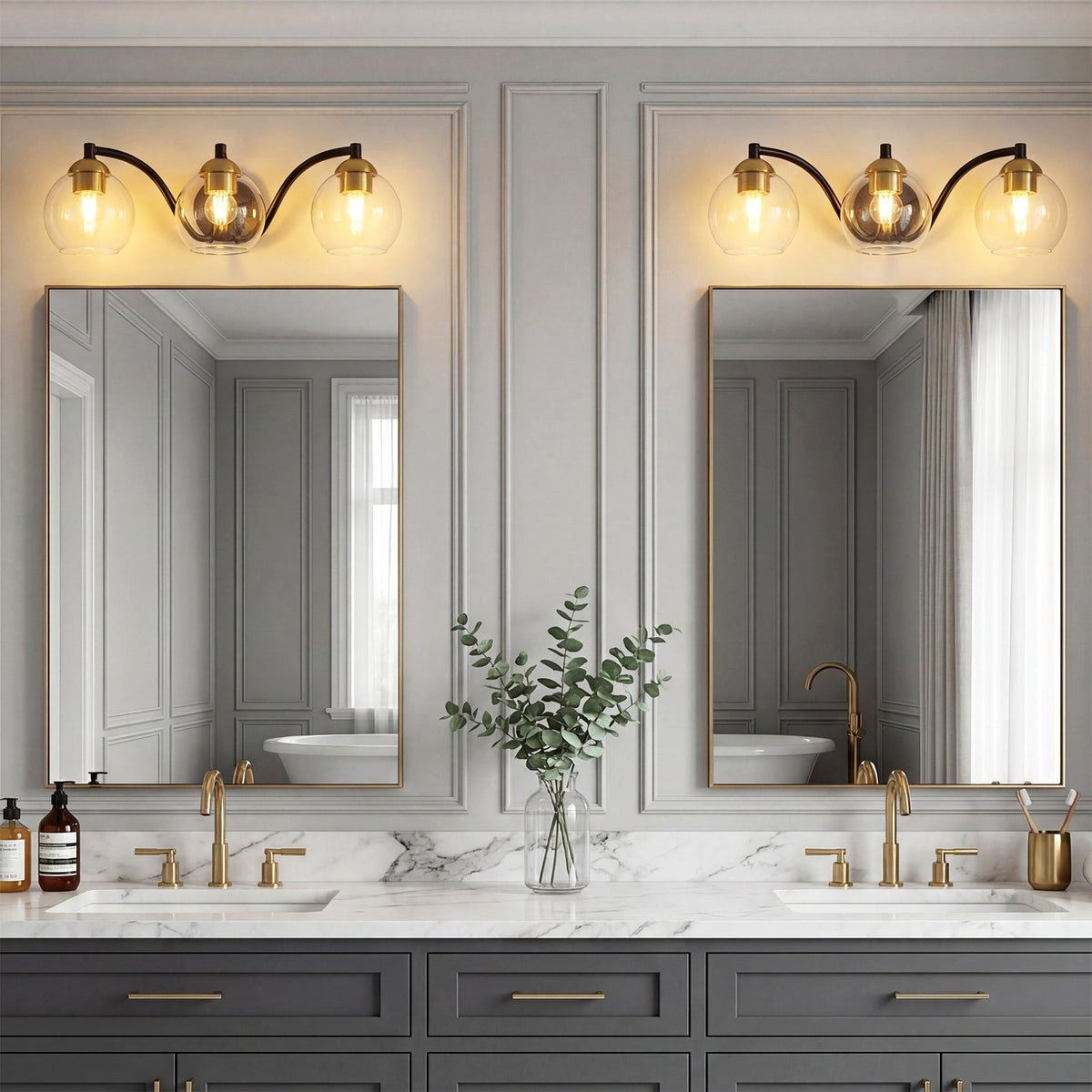 Black and brass bathroom vanity light with three clear globe shades, shown above a double sink