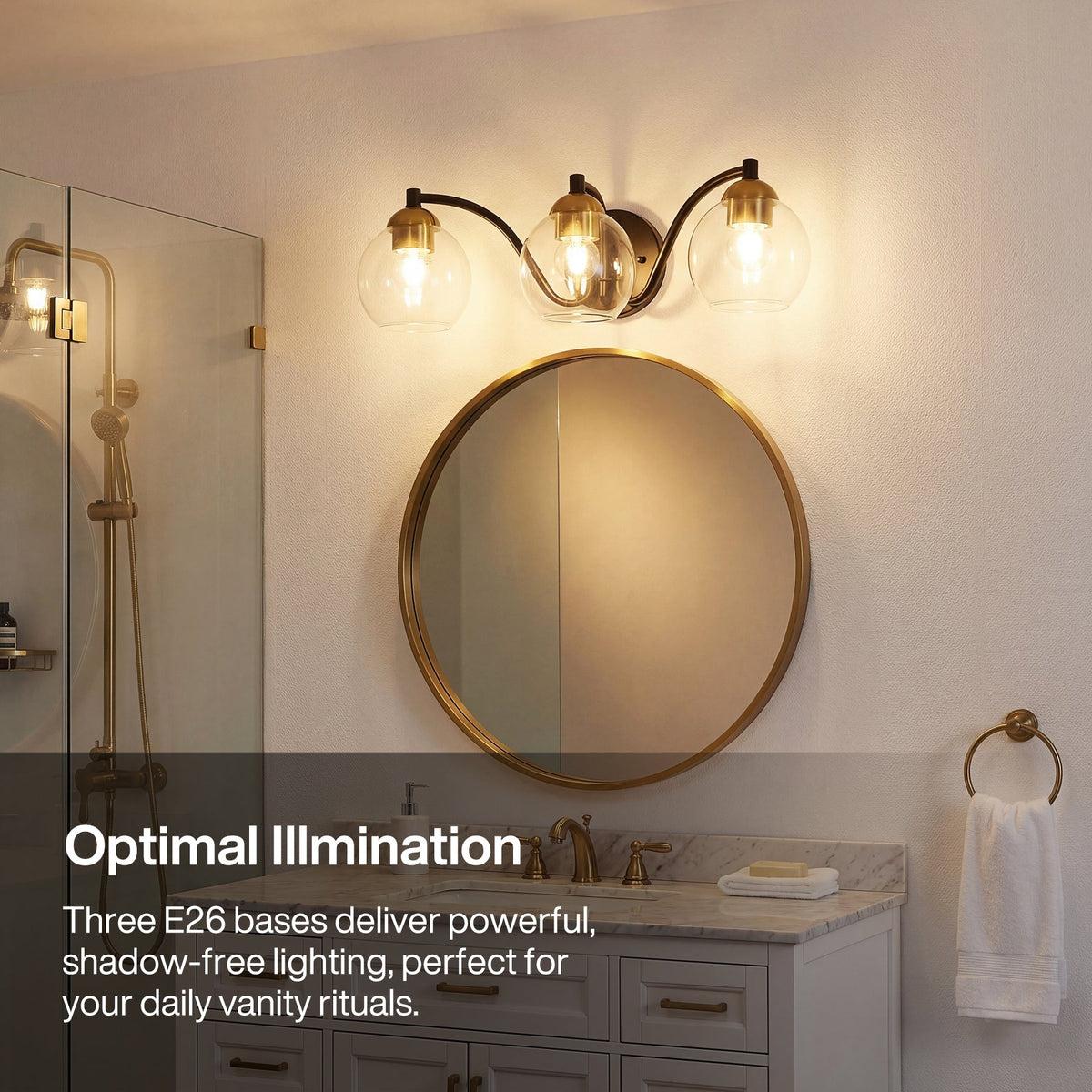 Black and brass three-light vanity light with clear globe shades mounted above a round mirror in a bathroom