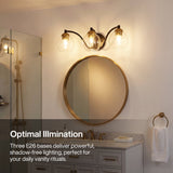 Black and brass three-light vanity light with clear globe shades mounted above a round mirror in a bathroom