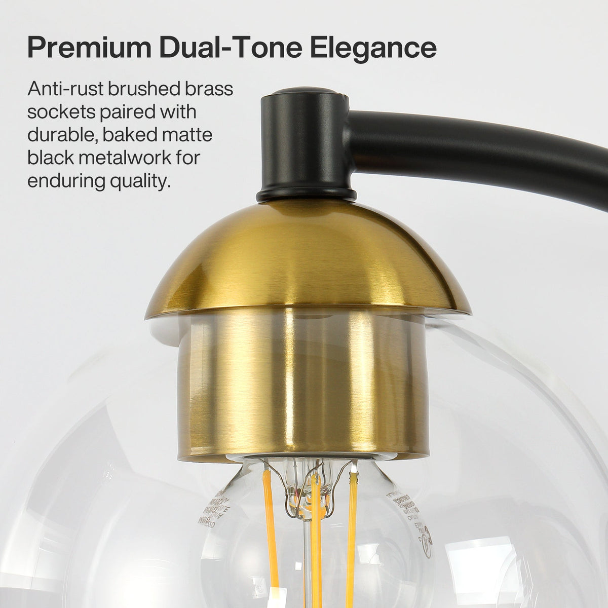 Close-up of black and brass bathroom vanity light with clear globe shade and visible filament bulb