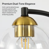 Close-up of black and brass bathroom vanity light with clear globe shade and visible filament bulb