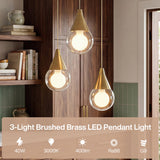 Three brushed brass pendant lights with glass globes hanging in a kitchen