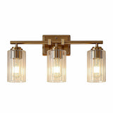 Brushed gold bathroom vanity light with three ribbed glass shades, shown lit from above