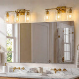 Brushed gold bathroom vanity light with three ribbed glass shades over a marble countertop