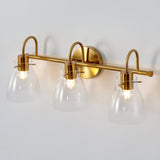 Three-light brushed brass vanity light with clear glass shades, shown from front angle