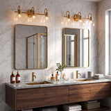 Brushed brass bathroom vanity light with three clear glass shades mounted above mirrors