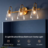 Three-light brushed brass vanity light with clear glass shades mounted above a mirror, 22.2*6.7*8.7 in