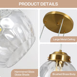 Close-up of brushed brass body of pendant light with hammered glass globe shade