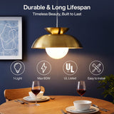 Brass dome pendant light with milk glass globe hanging over a wooden dining table