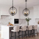 Black metal globe cage pendant light with gold bulbs, hanging over kitchen island