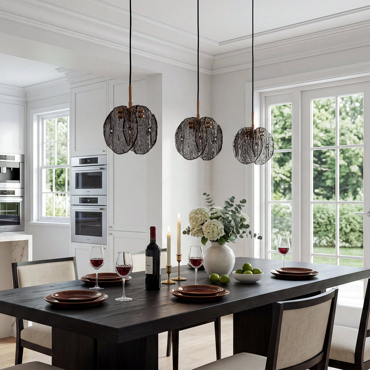 Three black pendant lights with smoky glass shades hang over a dining table