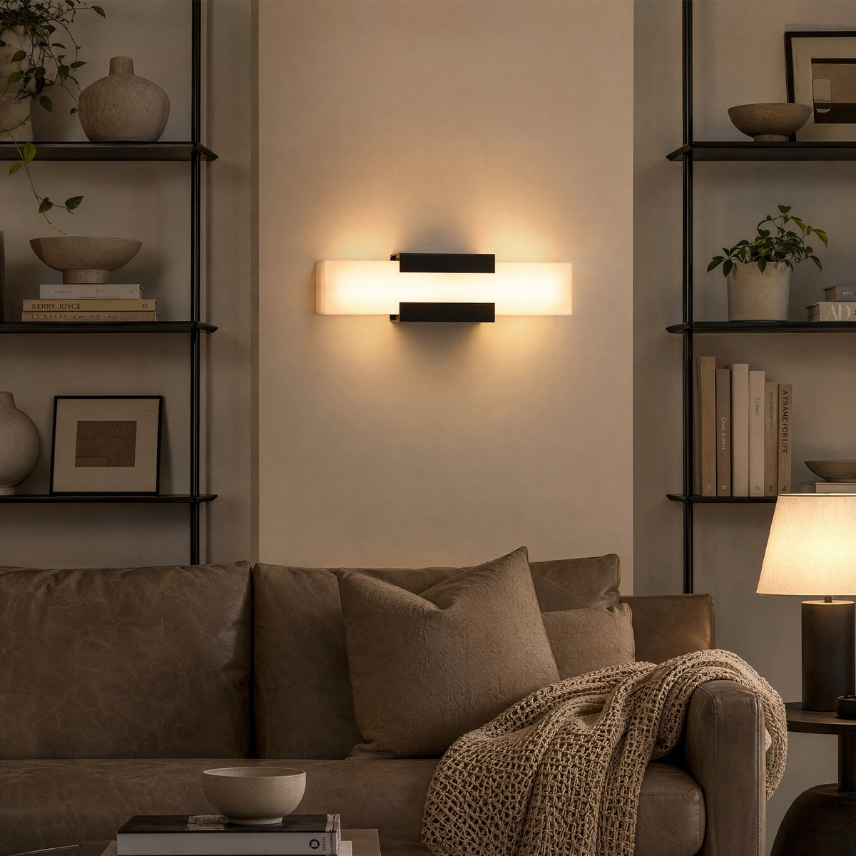 Black LED wall light with acrylic panels mounted on a wall above a sofa in a living room