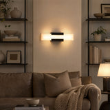 Black LED wall light with acrylic panels mounted on a wall above a sofa in a living room