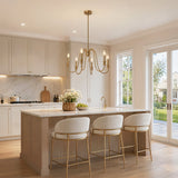 Gold six-light candle chandelier with U-shaped arms hanging over a kitchen island