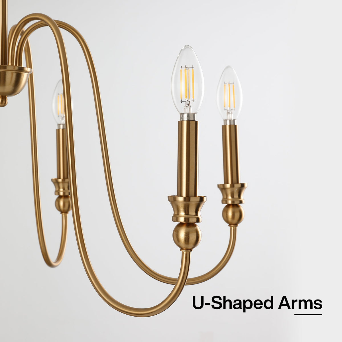 Gold candle chandelier with U-shaped arms and lit bulbs, angled view