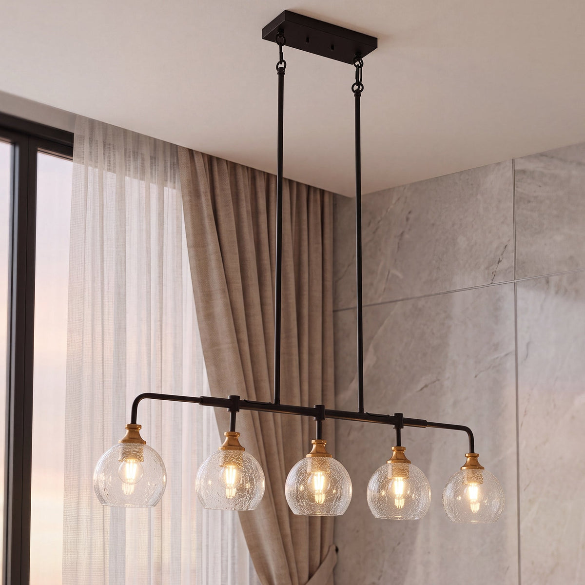 Five-light black and gold chandelier with crackle glass shades hanging in a kitchen