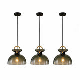 Three adjustable brass pendant lights with gradient green glass dome shades, shown lit