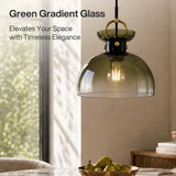 Brass pendant light with gradient green glass dome shade hanging in a dining room