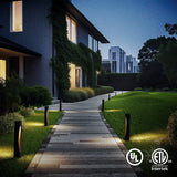 Six warm white low voltage LED path lights illuminate a stone walkway beside green grass