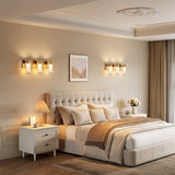 Gold LED wall sconce with three lights mounted on bedroom wall above bed