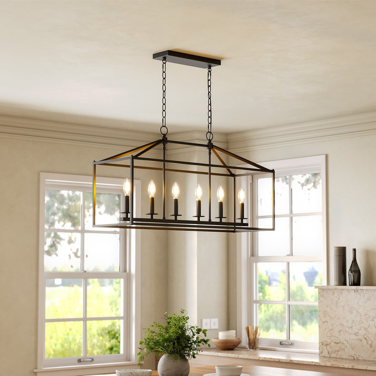 Black metal six-light farmhouse chandelier with candle-style bulbs hanging over a kitchen island
