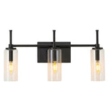 Black bathroom vanity light with three clear cylinder glass shades, shown lit from front