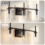 Black bathroom vanity light with three clear cylinder glass shades, shown off and on