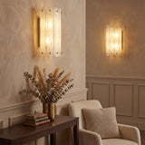 Brass wall sconce with cloud glass shades mounted on beige wall in living room