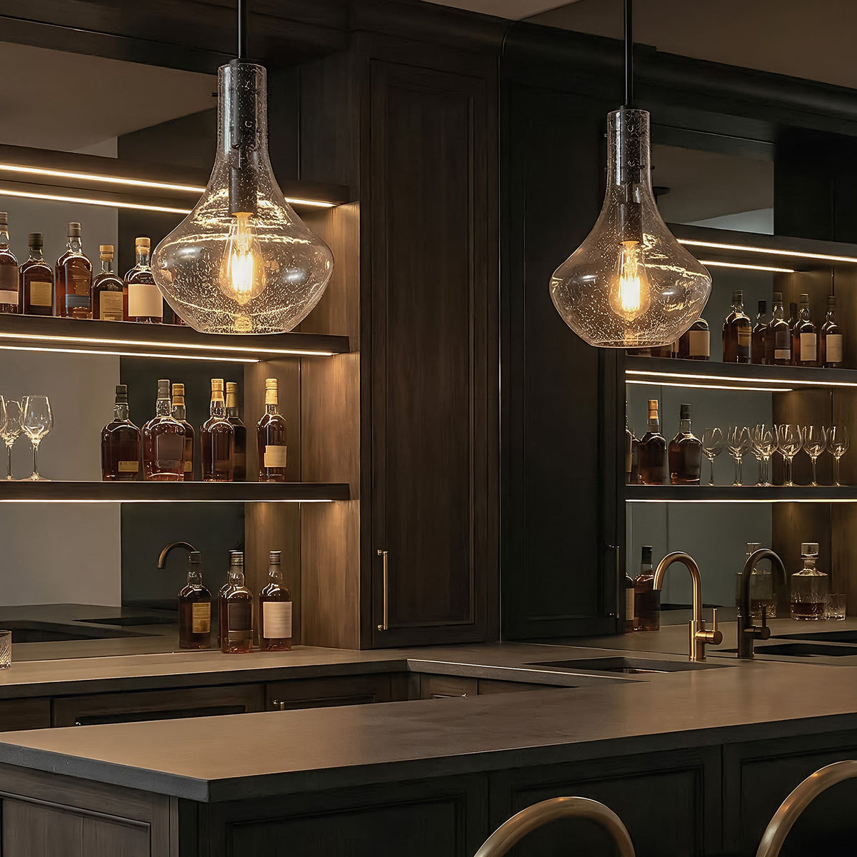 Black mini pendant light with bubble glass shade hanging over a bar counter