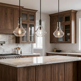 Three black mini pendant lights with bubble glass shades hang over a kitchen island