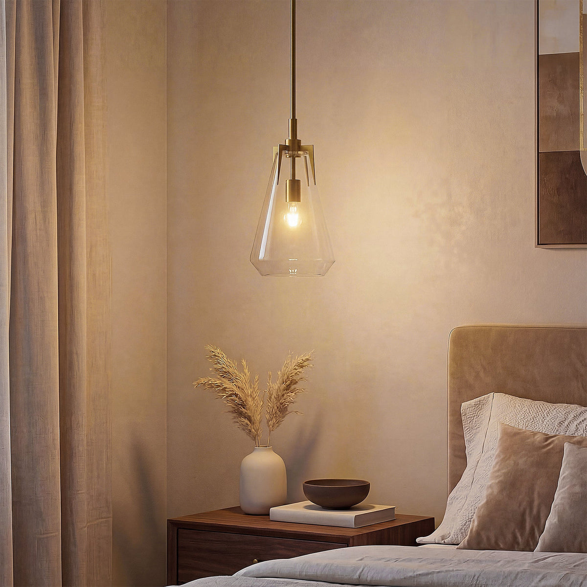 Gold pendant light with clear glass shade hanging in a bedroom