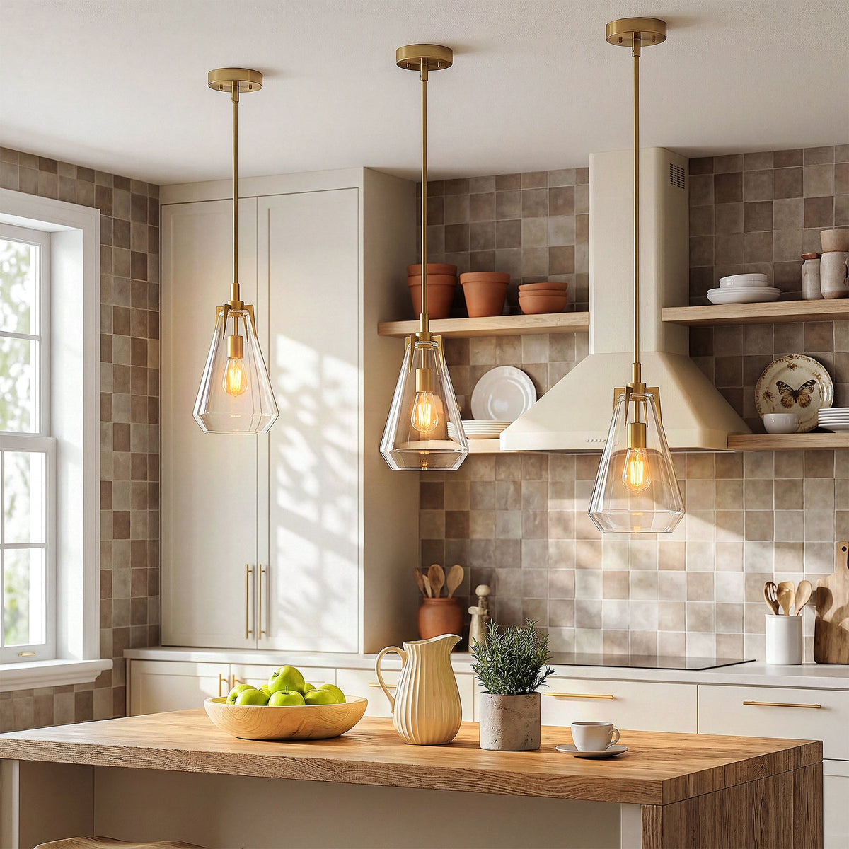 Three gold pendant lights with clear glass shades hang over a wooden kitchen island