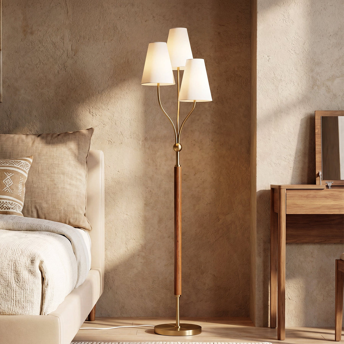 Gold floor lamp with three linen shades and rubberwood handle, shown in bedroom setting